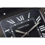 Macro of the black dial: white Roman numerals and a lume-filled sword minute hand