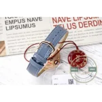 The fluted crown carries a blue synthetic spinel cabochon, integrated into the case contour