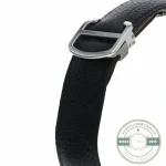 Buckle end of the black strap, steel tongue squared off against the leather