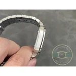 Steel bracelet arched in the hand, showing the taper from case to clasp