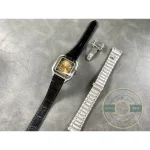 Watch laid out with its spare steel bracelet, buckle and strap-change tool