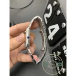 Case flank turned outward, the crown cabochon reading blue in the light