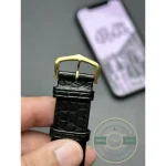 Gold pin buckle matched to the case, black alligator passing through it