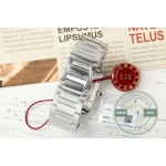 Bracelet links beside a red branded disc, polished faces reflecting
