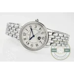 Watch laid down with the bracelet coiled, crown facing the camera at three