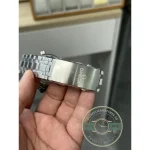 Wave engraving casting shadow lines across the grey dial of this Seamaster clone
