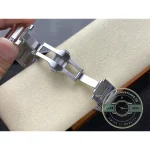 A bracelet of polished steel fastens on a deployment clasp at the wrist