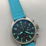 Teal subdial hands set against a sunray-brushed dark grey ground