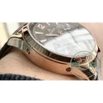 12-hour chronograph register at 9 o'clock, pink gold hand against the grained charcoal surface