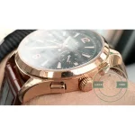 Brown alligator strap with tonal stitching meeting the polished pink gold lug