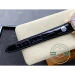 Black alligator strap detail, square scales running toward the pink gold buckle