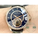 Pink gold leaf hands over the polished rail that circles the centre of the dial