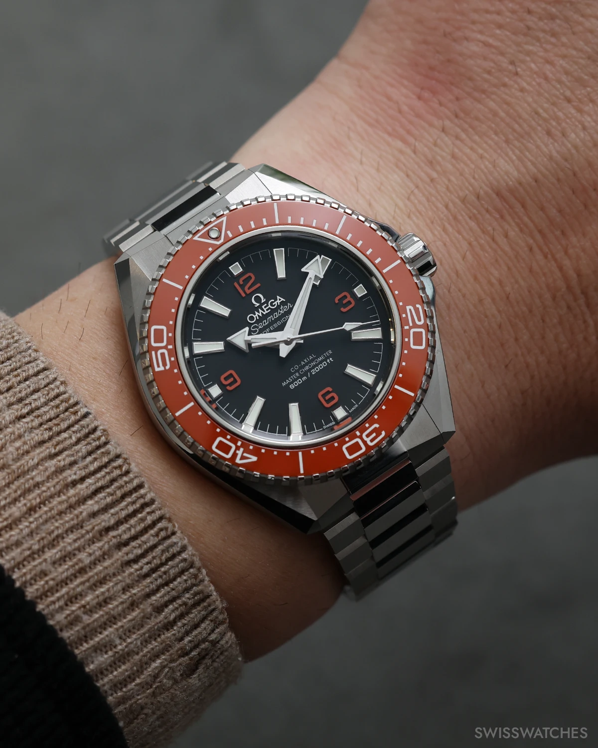 Omega Planet Ocean 600M on wrist with orange bezel steel bracelet