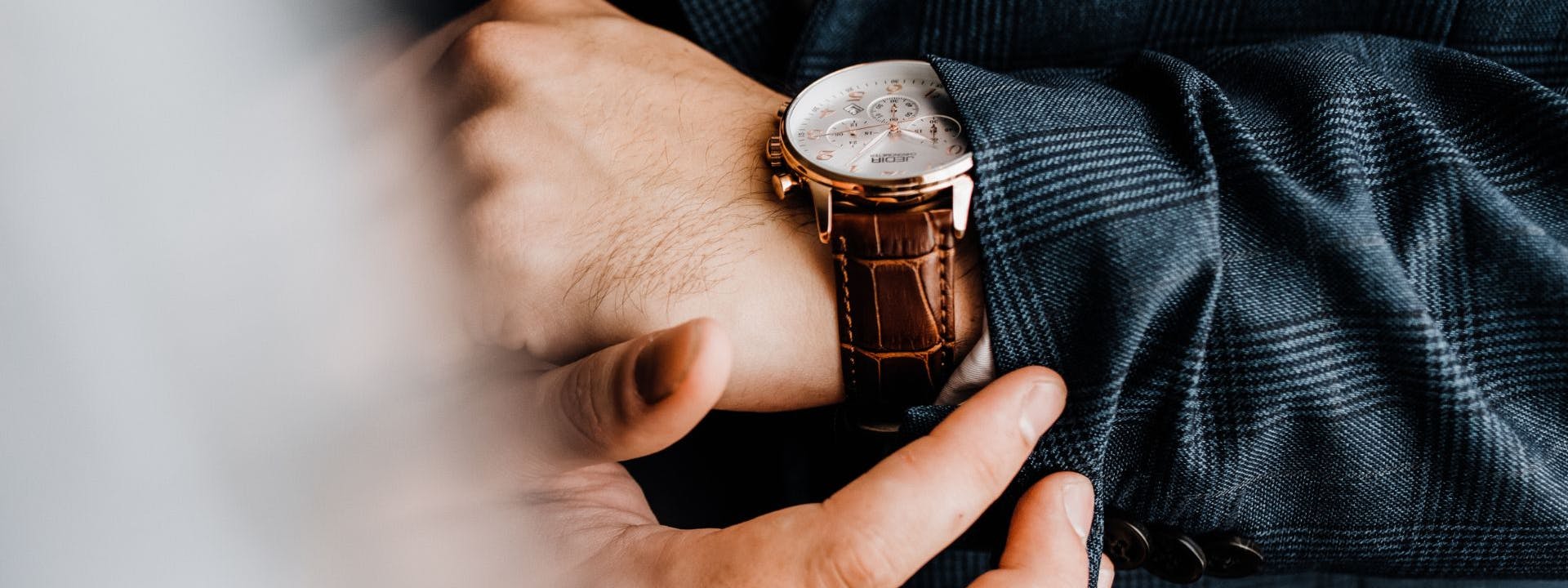 Luxury watch on wrist with suit