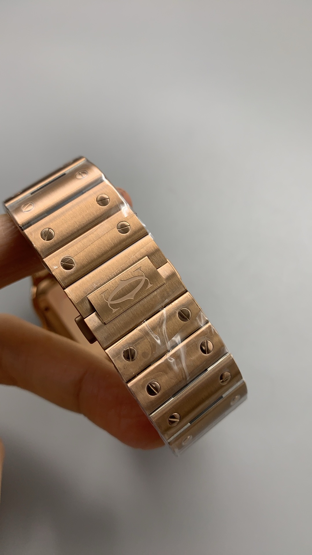 Gold bracelet held upright, clasp cover carrying the double-C motif