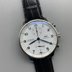 Heat-blued steel leaf hands travel over a white chronograph ground