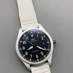 The dial reads as a dark window cut into a white case, matte throughout