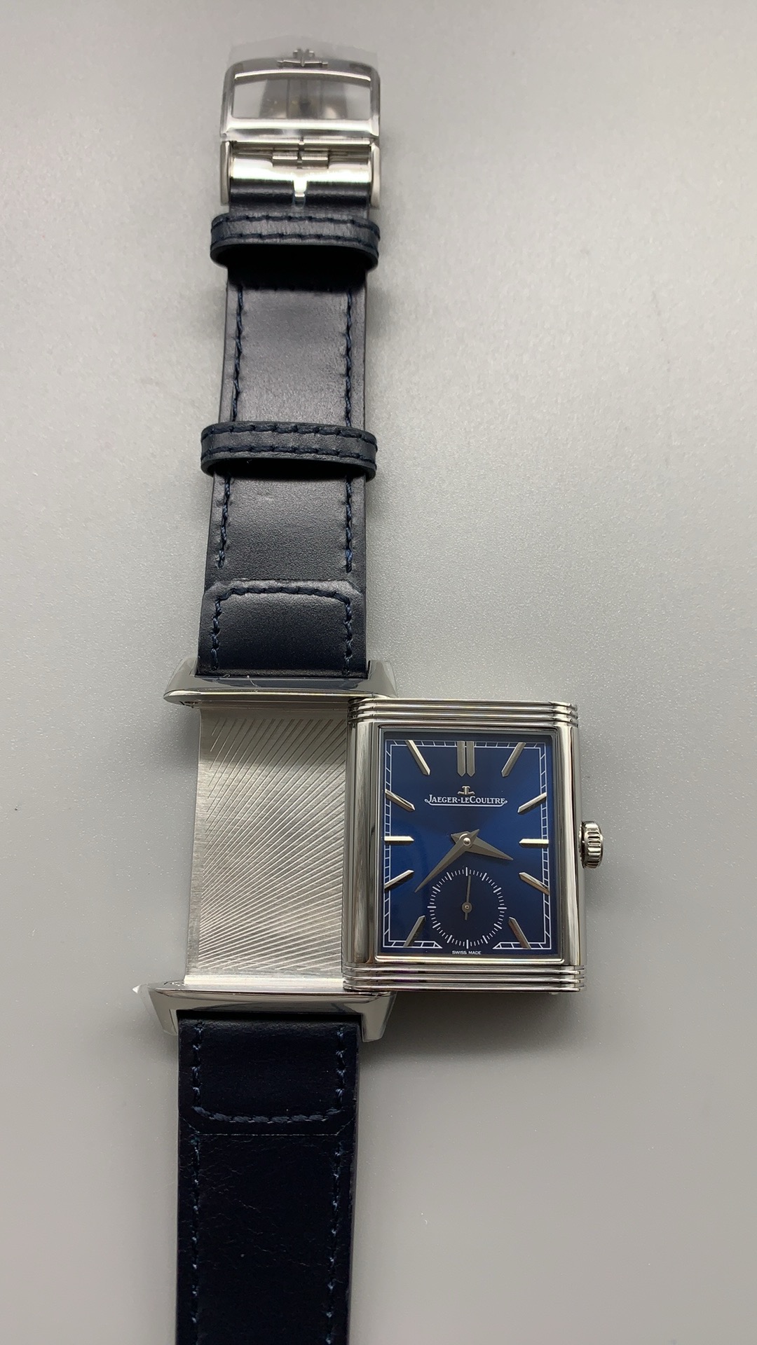 Steel pin buckle closed on the blue leather strap with the tail tucked through the keeper
