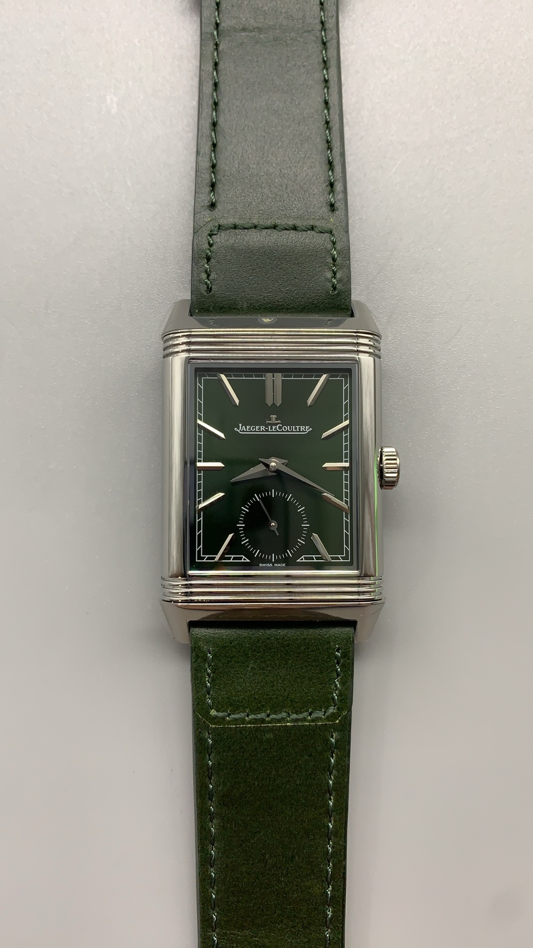 Three-quarter view of the green Reverso Tribute Monoface replica, steel case on green leather