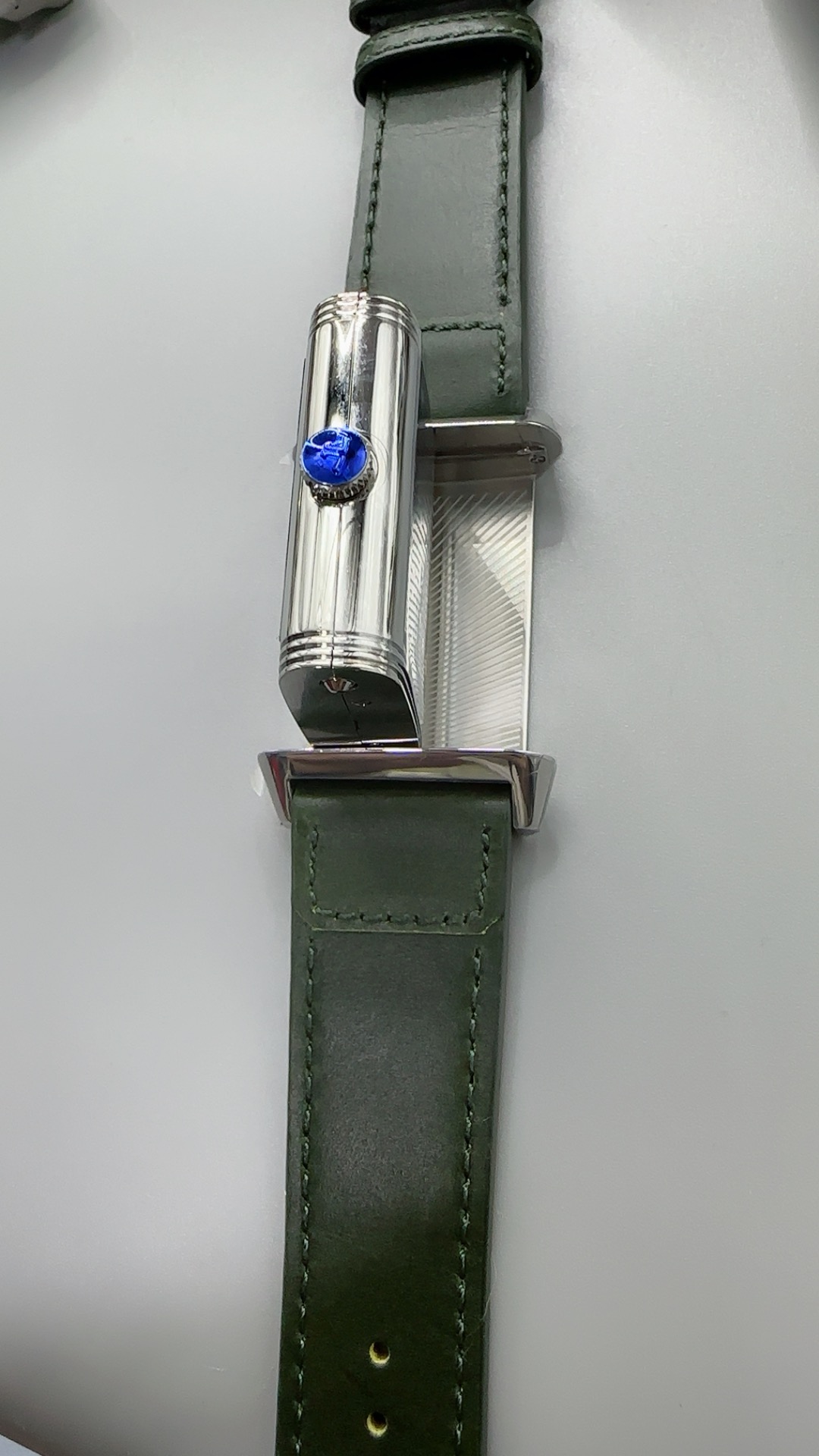 Green Reverso dial at an angle, sun-ray finish darkening toward the edges under raking light