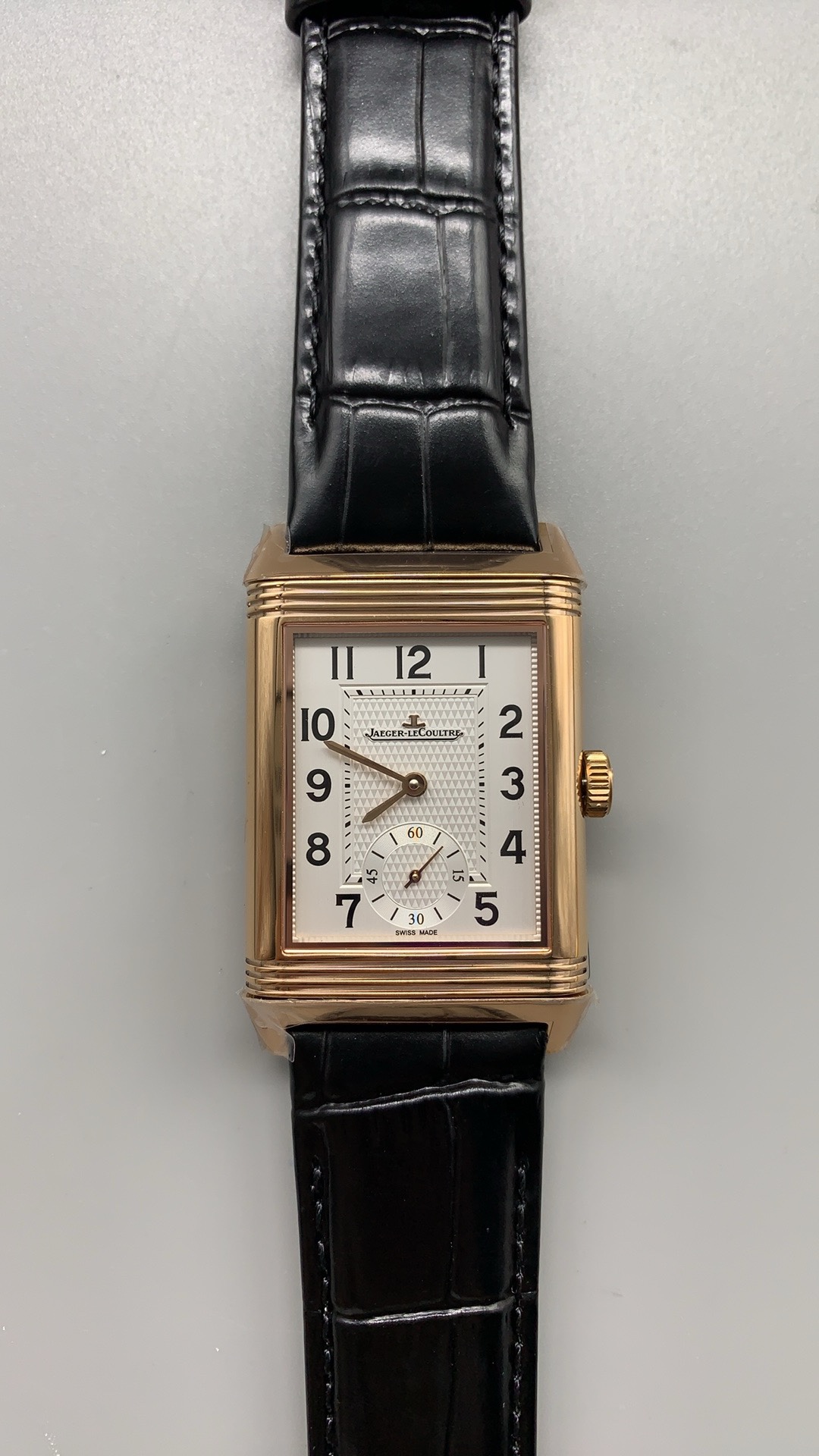 Guilloché texture of the silver dial raking the light at an angle on this Reverso super clone