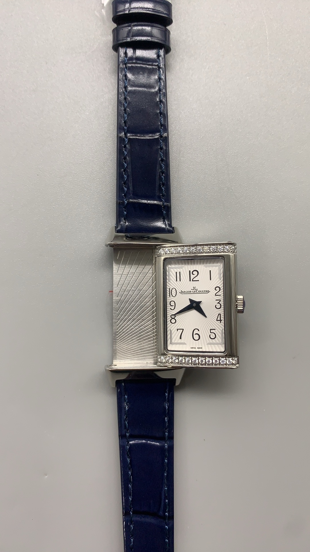 Side profile of the slim rectangular women's case with the blue alligator strap attached