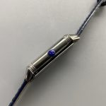 Flat lay of the Q3288420 replica with the blue alligator strap coiled beside the steel case