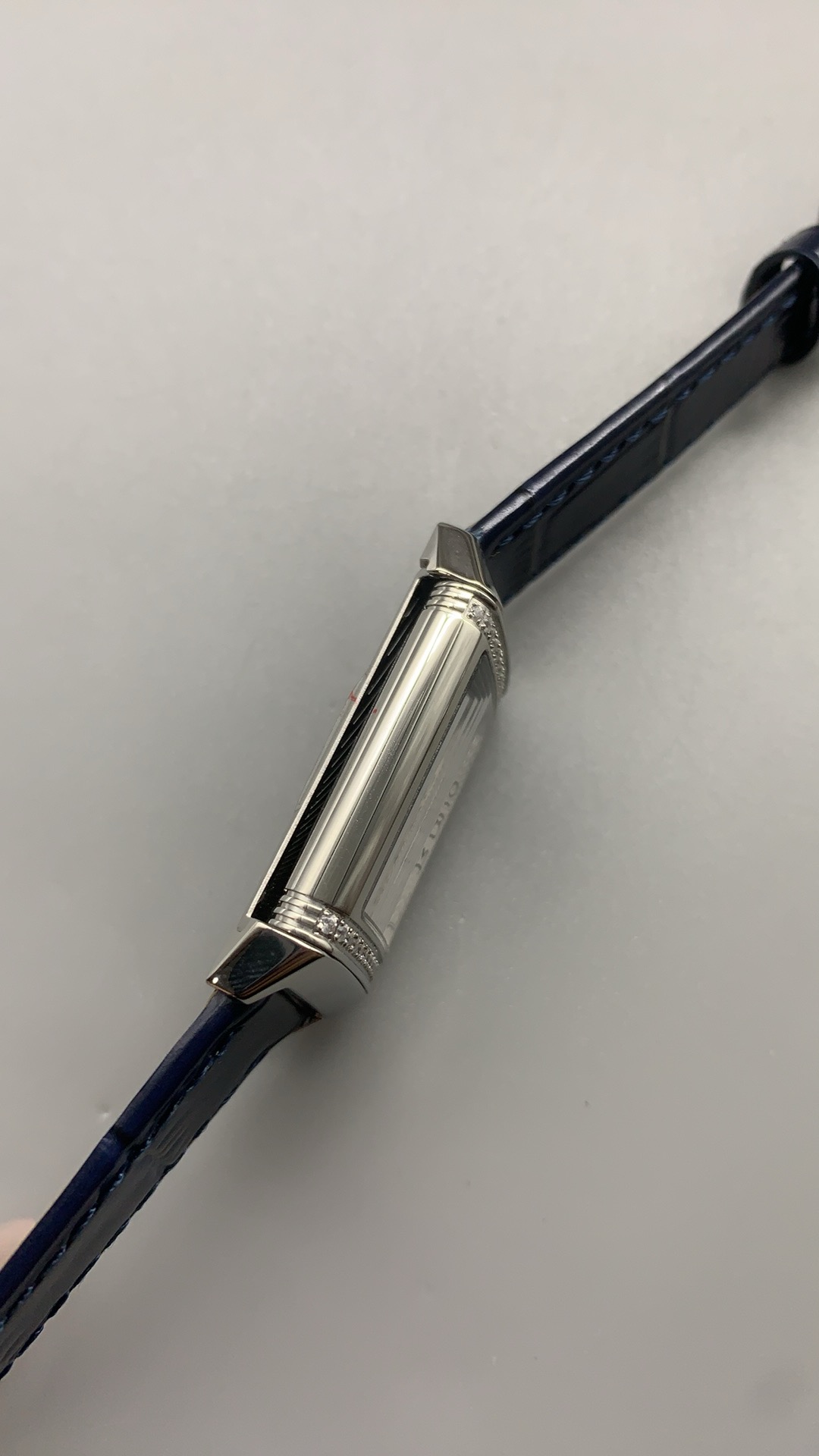 Dial edge and black numerals framed by the polished flank of the rectangular steel case