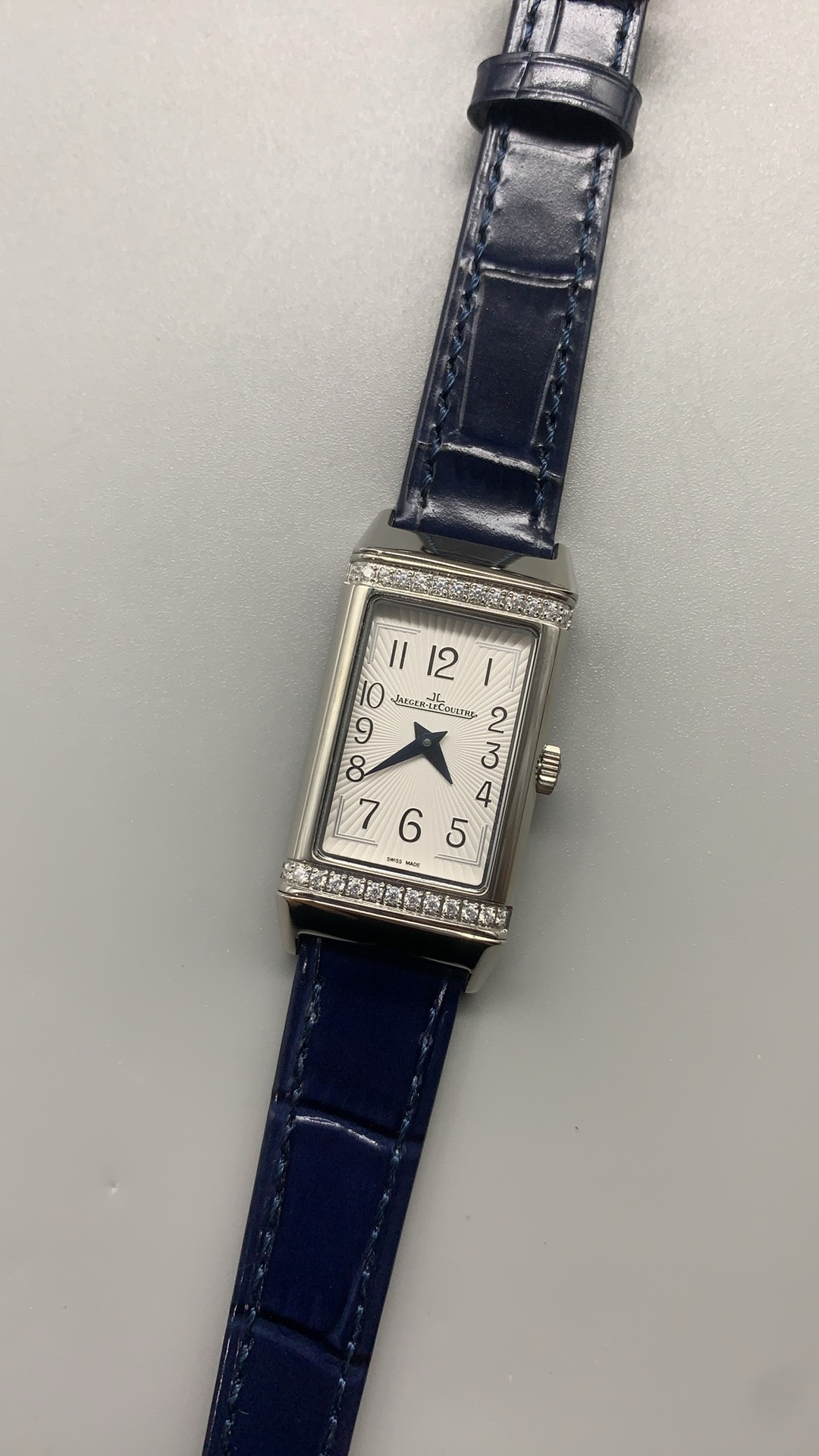 Sapphire crystal viewed at a low angle above the silvered guilloche dial of the Q3288420