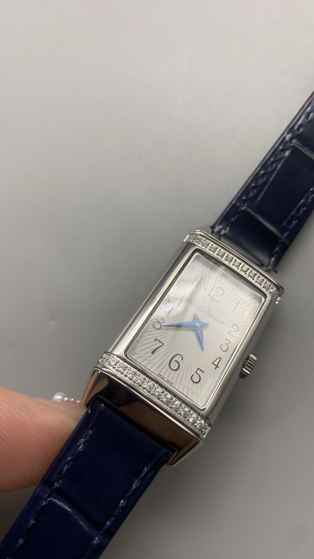 Women's Reverso super clone worn on the wrist, compact rectangular steel case on blue alligator