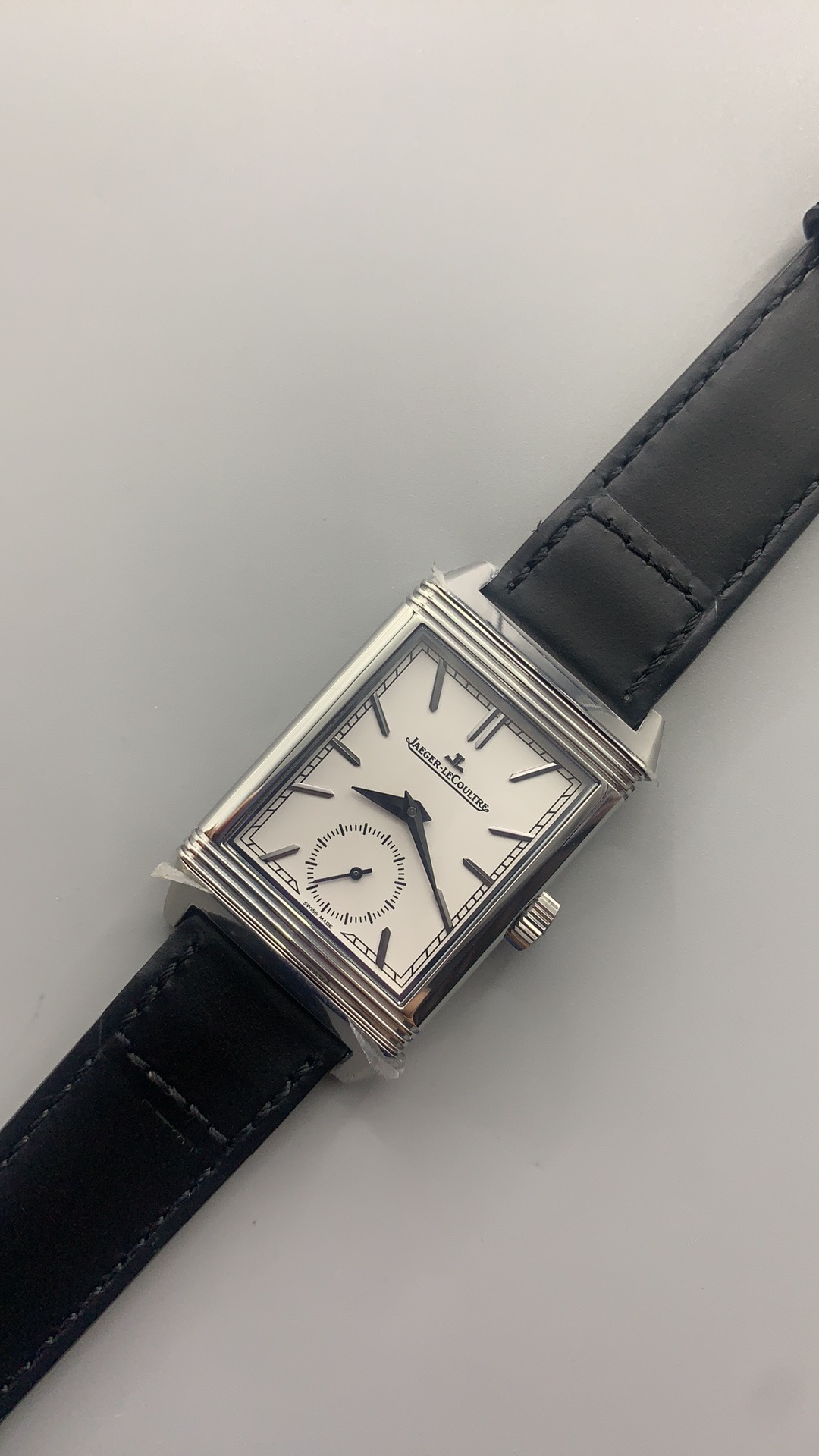 Polished flutes along the edge of the rectangular stainless steel Reverso case frame