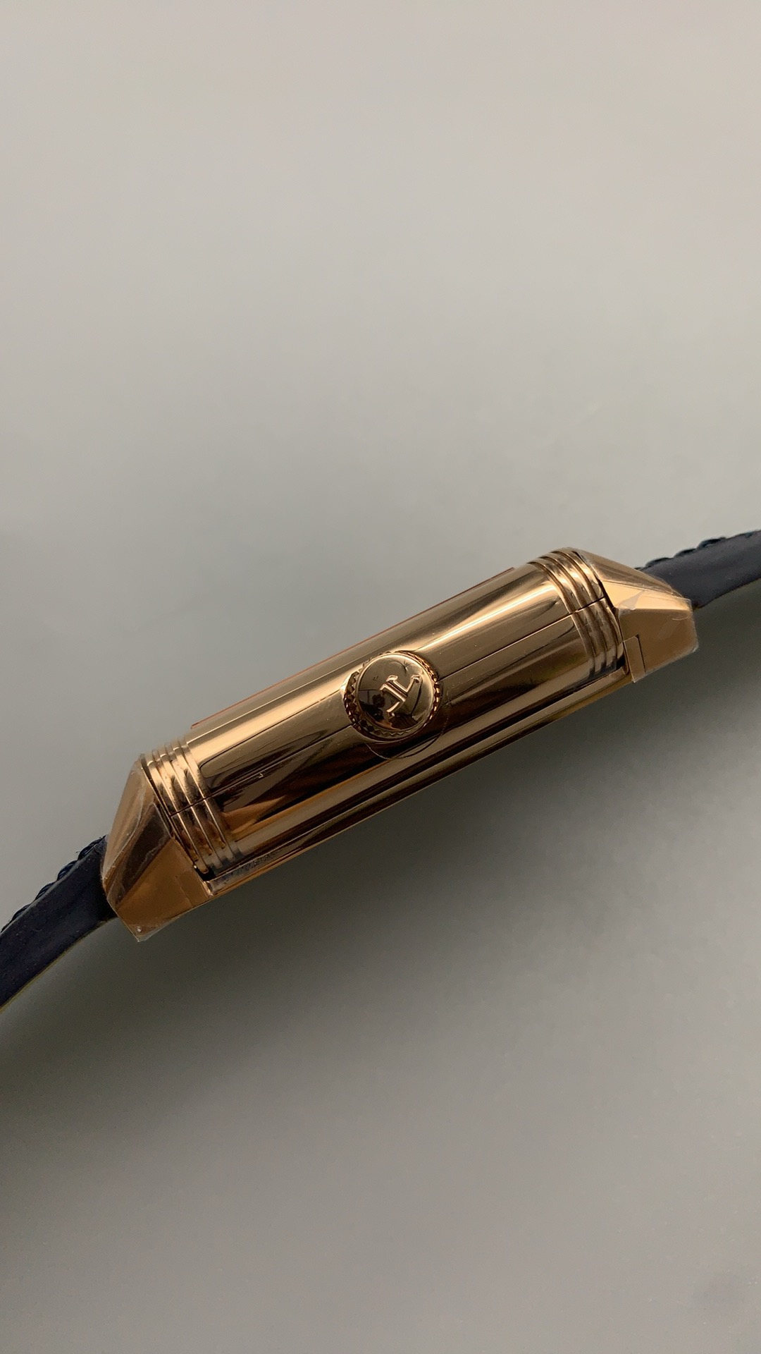 Rose gold Reverso Duoface replica caught mid-turn, case swung out of its rectangular cradle