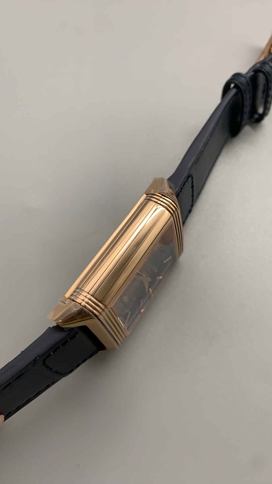 Macro of the thin gold perimeter track and applied gold batons on the blue Reverso dial