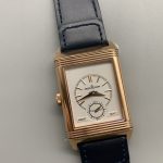 Gold hands over the blue dial at a tilted angle, sunray finish catching the light