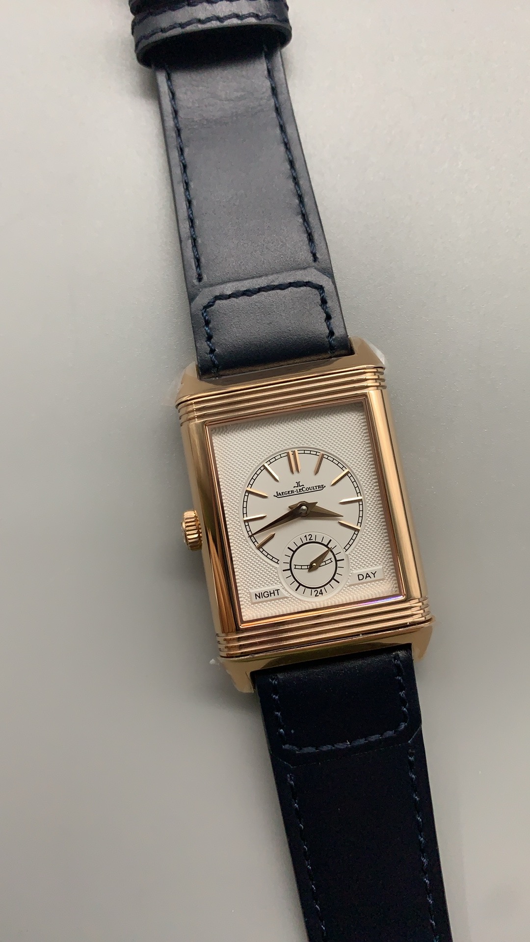 Gold hands over the blue dial at a tilted angle, sunray finish catching the light